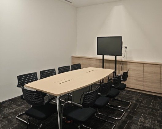 Meeting room with a table and a wall-mounted screen